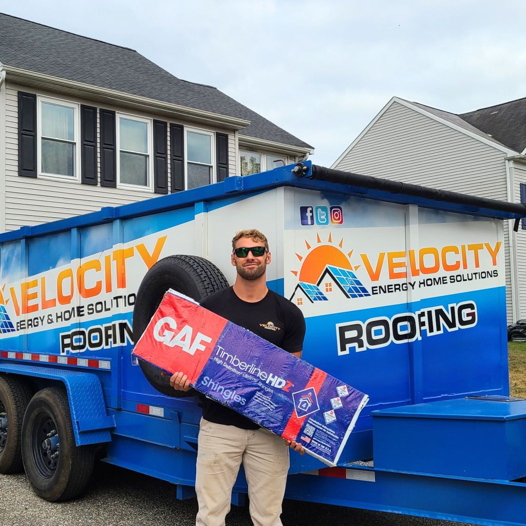 Velocity Roofing team member holding GAF Timberline HDZ shingles on the job